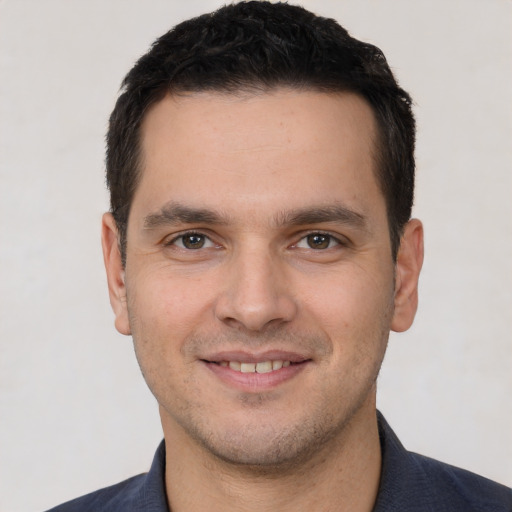 Joyful white young-adult male with short  brown hair and brown eyes