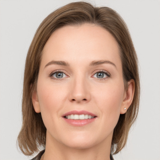 Joyful white young-adult female with medium  brown hair and grey eyes