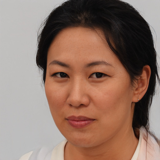 Joyful asian adult female with medium  brown hair and brown eyes