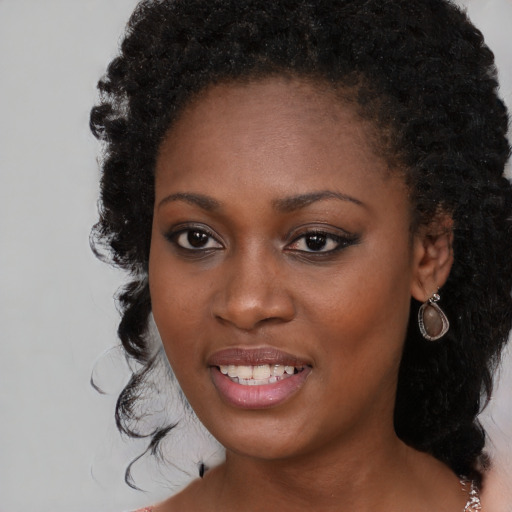 Joyful black young-adult female with long  black hair and brown eyes