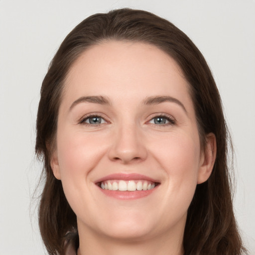 Joyful white young-adult female with long  brown hair and grey eyes