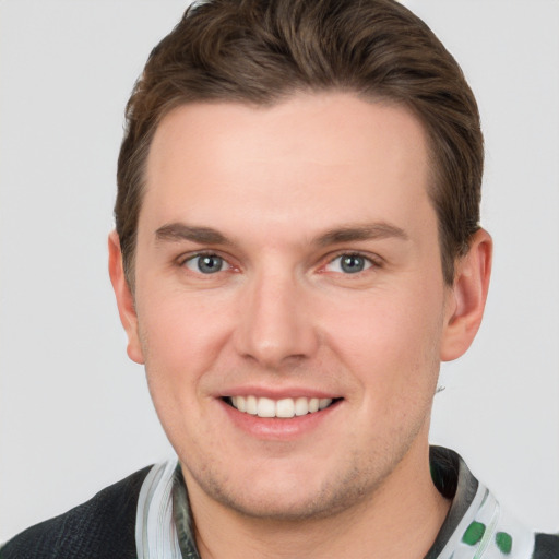 Joyful white young-adult male with short  brown hair and grey eyes