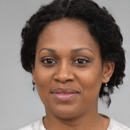 Joyful black adult female with short  brown hair and brown eyes