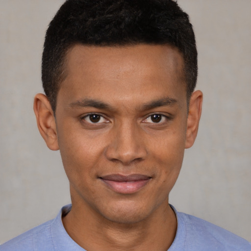 Joyful latino young-adult male with short  brown hair and brown eyes