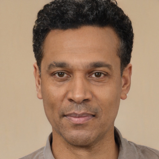 Joyful latino adult male with short  black hair and brown eyes