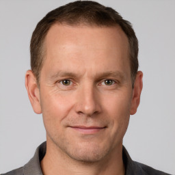 Joyful white adult male with short  brown hair and grey eyes