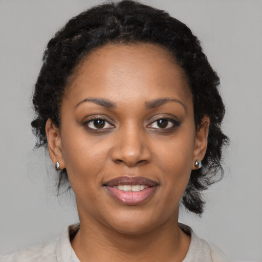 Joyful black young-adult female with medium  brown hair and brown eyes