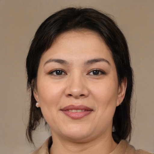 Joyful latino adult female with medium  brown hair and brown eyes