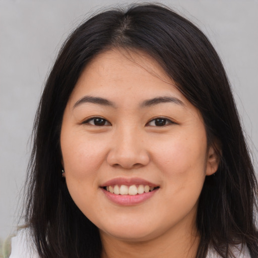 Joyful asian young-adult female with long  brown hair and brown eyes