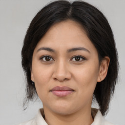 Joyful latino young-adult female with medium  brown hair and brown eyes