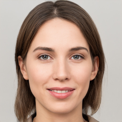 Joyful white young-adult female with medium  brown hair and grey eyes