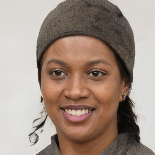 Joyful black young-adult female with short  brown hair and brown eyes