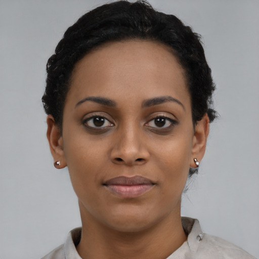 Joyful black young-adult female with short  black hair and brown eyes