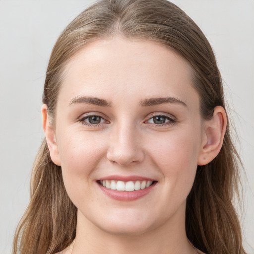 Joyful white young-adult female with long  brown hair and grey eyes