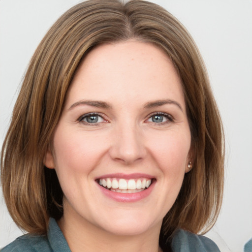 Joyful white young-adult female with medium  brown hair and green eyes