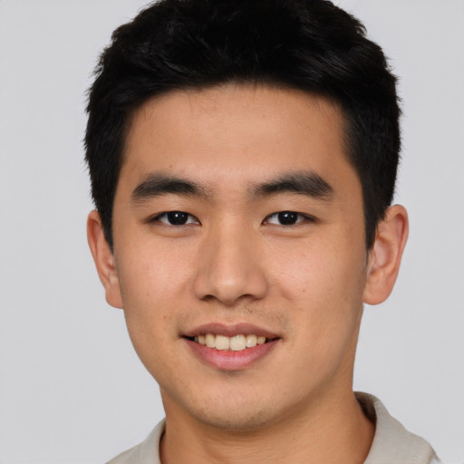 Joyful asian young-adult male with short  black hair and brown eyes