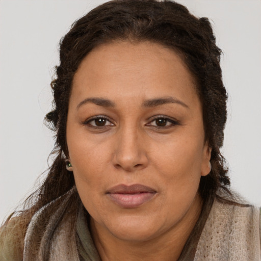 Joyful latino adult female with long  brown hair and brown eyes