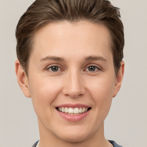 Joyful white young-adult female with short  brown hair and grey eyes