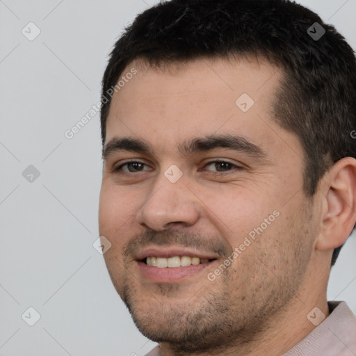 Joyful white young-adult male with short  black hair and brown eyes