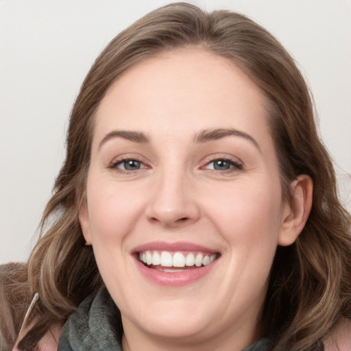 Joyful white young-adult female with long  brown hair and grey eyes