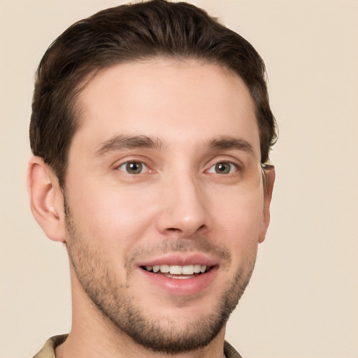 Joyful white young-adult male with short  brown hair and grey eyes