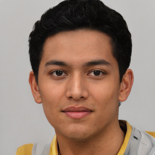 Joyful latino young-adult male with short  black hair and brown eyes