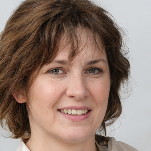 Joyful white adult female with medium  brown hair and grey eyes