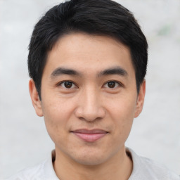 Joyful asian young-adult male with short  black hair and brown eyes