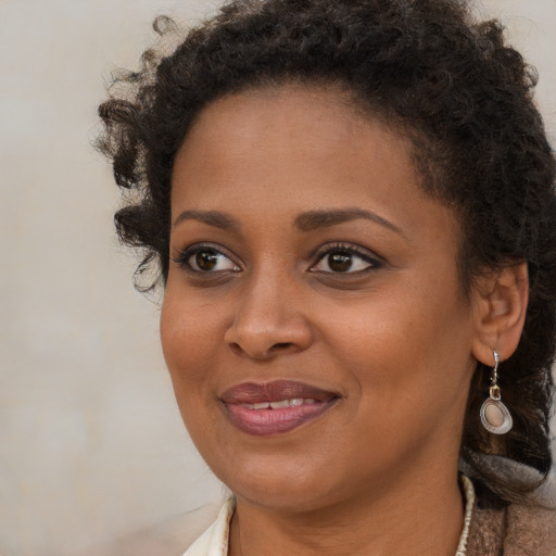 Joyful black young-adult female with medium  brown hair and brown eyes