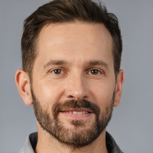 Joyful white adult male with short  brown hair and brown eyes