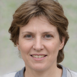 Joyful white adult female with medium  brown hair and grey eyes