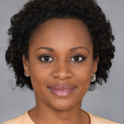 Joyful black young-adult female with medium  brown hair and brown eyes