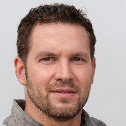 Joyful white adult male with short  brown hair and grey eyes