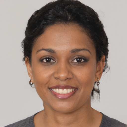 Joyful black young-adult female with short  brown hair and brown eyes