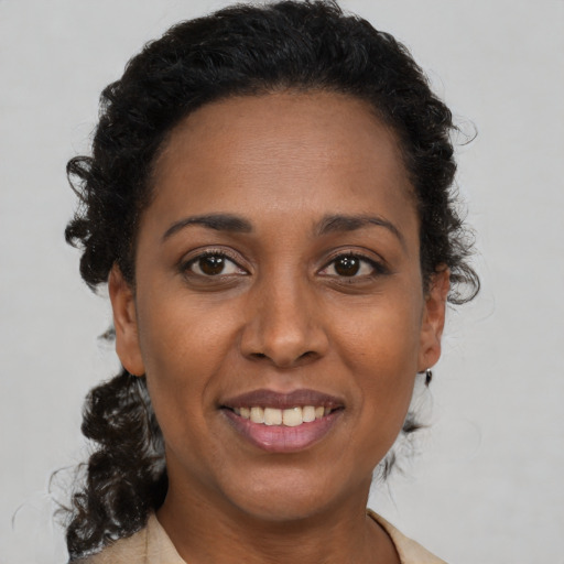 Joyful black young-adult female with medium  brown hair and brown eyes