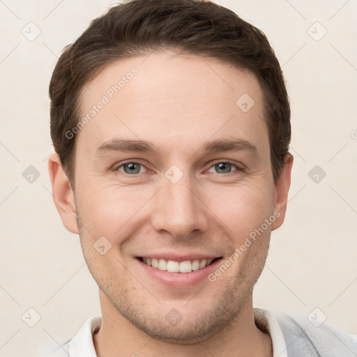 Joyful white young-adult male with short  brown hair and grey eyes