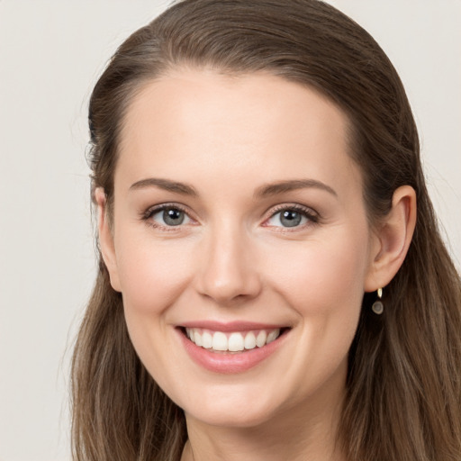 Joyful white young-adult female with long  brown hair and grey eyes