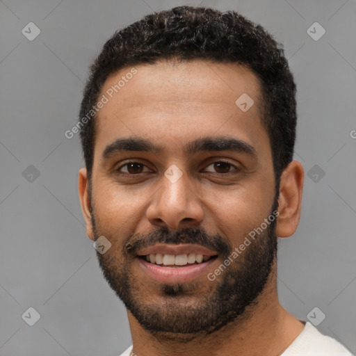 Joyful black young-adult male with short  black hair and brown eyes