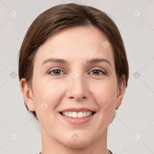 Joyful white young-adult female with short  brown hair and grey eyes