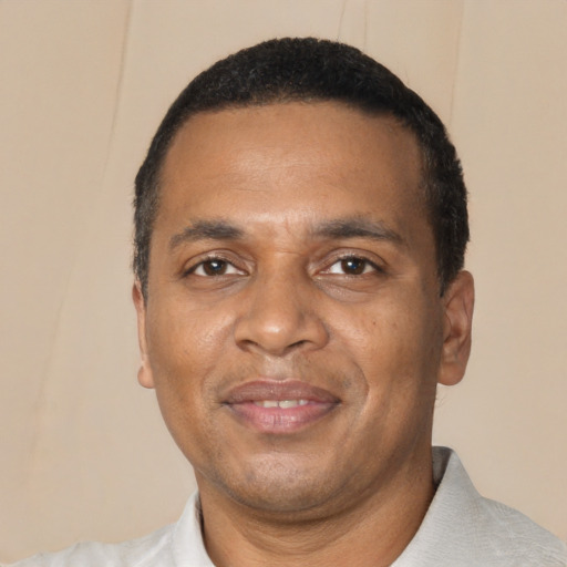Joyful black adult male with short  black hair and brown eyes