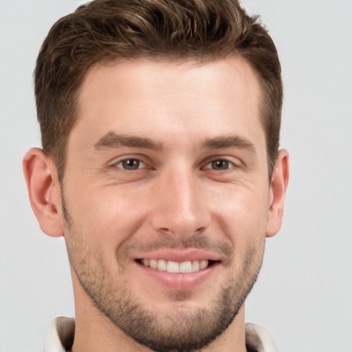 Joyful white young-adult male with short  brown hair and grey eyes