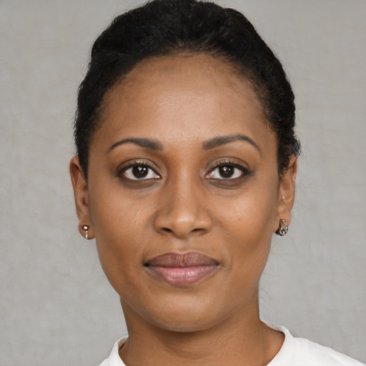 Joyful black young-adult female with short  black hair and brown eyes