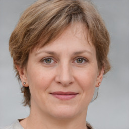 Joyful white adult female with medium  brown hair and grey eyes