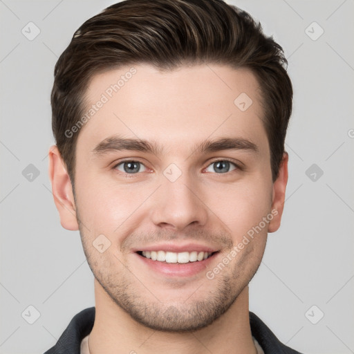 Joyful white young-adult male with short  brown hair and grey eyes