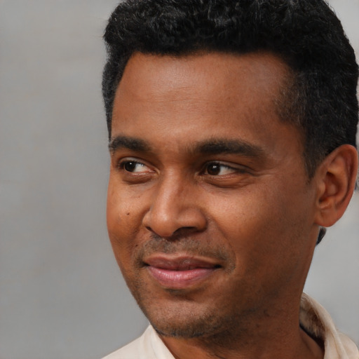Joyful latino young-adult male with short  black hair and brown eyes