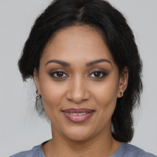 Joyful black adult female with medium  brown hair and brown eyes
