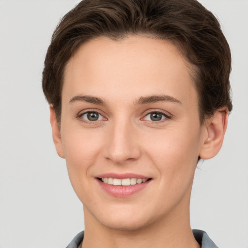 Joyful white young-adult female with short  brown hair and grey eyes