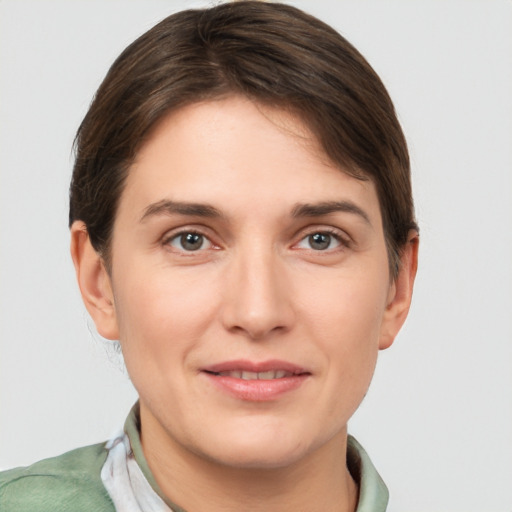 Joyful white young-adult female with short  brown hair and grey eyes