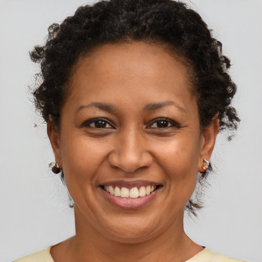 Joyful black adult female with short  brown hair and brown eyes