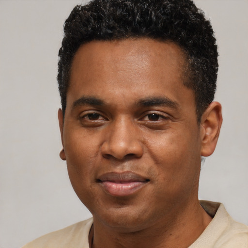 Joyful black young-adult male with short  black hair and brown eyes